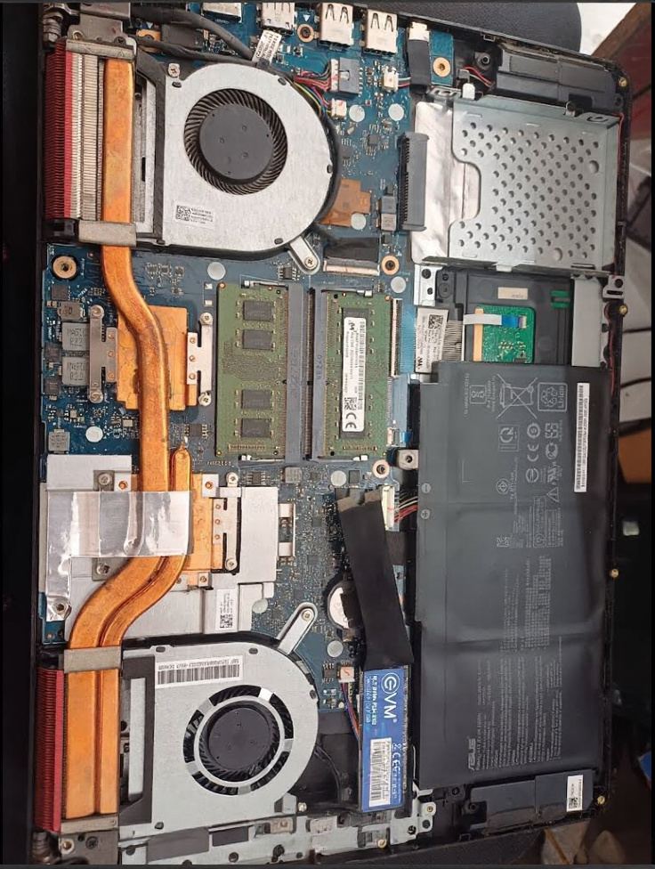 ASUS laptop with the back cover removed showing dual RAM slots, heat pipes and SSD