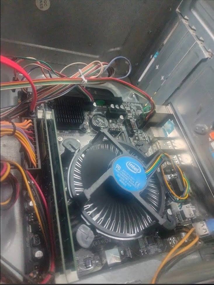Desktop PC interior with the CPU cooler and motherboard exposed during servicing